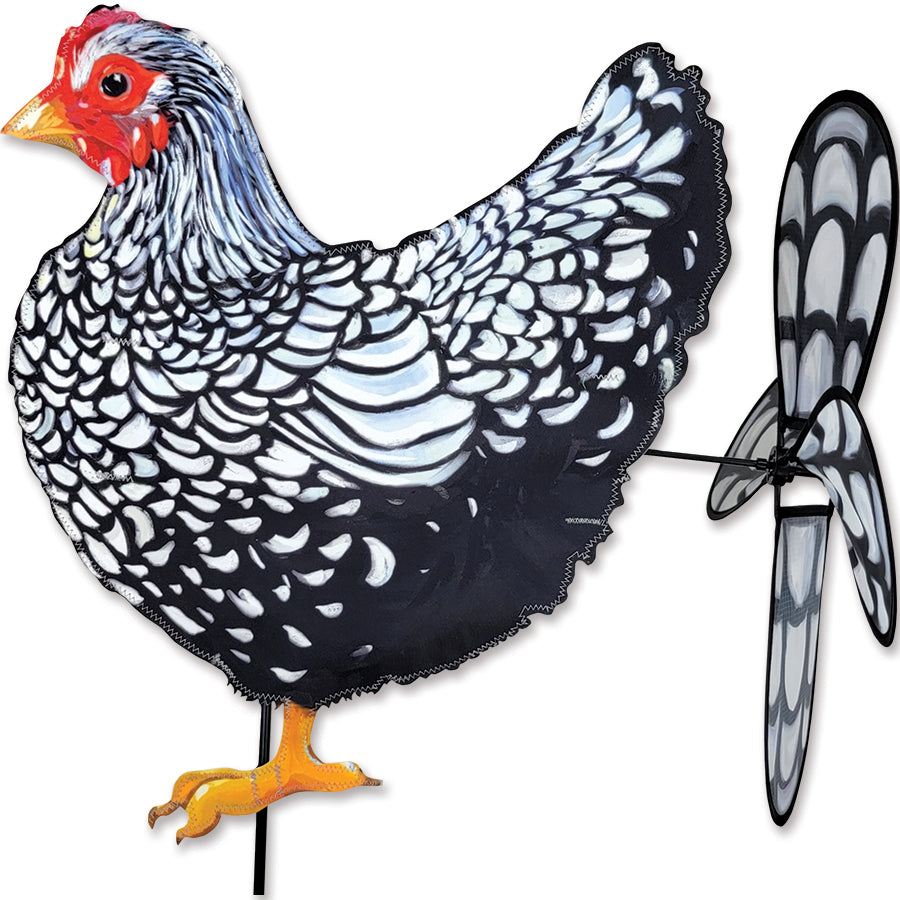Deluxe Petite Spinner featuring a black and white chicken design, elegantly spinning in a garden setting with colorful flowers in the background.
