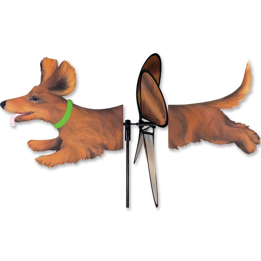Deluxe Petite Spinner in the shape of a dachshund displaying vibrant colors while spinning in a gentle breeze in a garden setting.