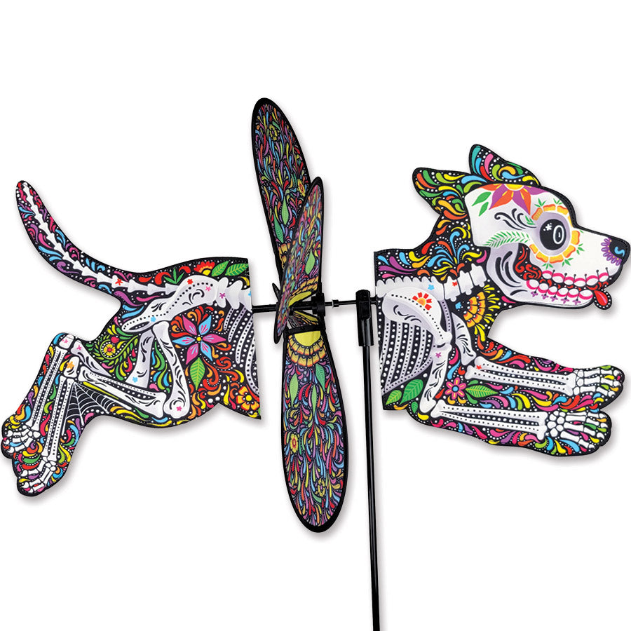 Deluxe Petite Spinner in Day of the Dead Dog design spinning in a colorful outdoor garden setting, showcasing vibrant colors.