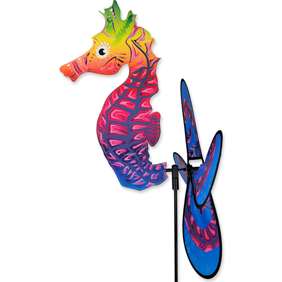 Deluxe Petite Spinner - Sea Horse elegantly rotating in a vibrant garden setting with flowers surrounding it.