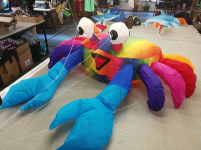 Compact rainbow bouncing crab kite accessory designed to hop and move in the wind, adding playful color and motion to beach and lawn displays.