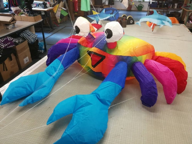 Compact rainbow bouncing crab kite accessory designed to hop and move in the wind, adding playful color and motion to beach and lawn displays.