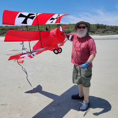Giant 65 inch Red Baron tri-plane kite with vintage WWI design, spinning propellers, durable frame, and 130 lb. line with storage case included.