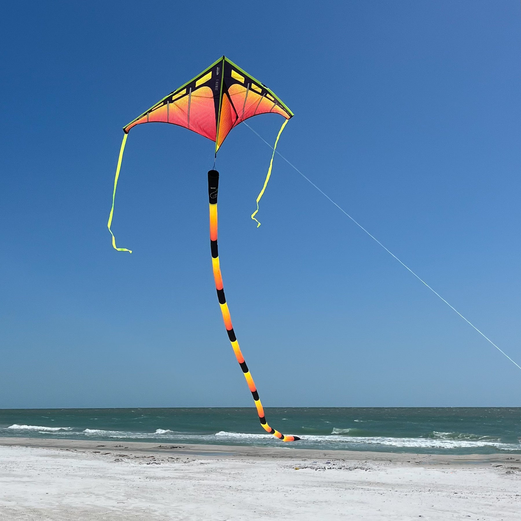 Infrared tube tail with red, orange, and yellow gradient, inflating tubular construction, and swivel clip for dynamic kite motion and visibility.