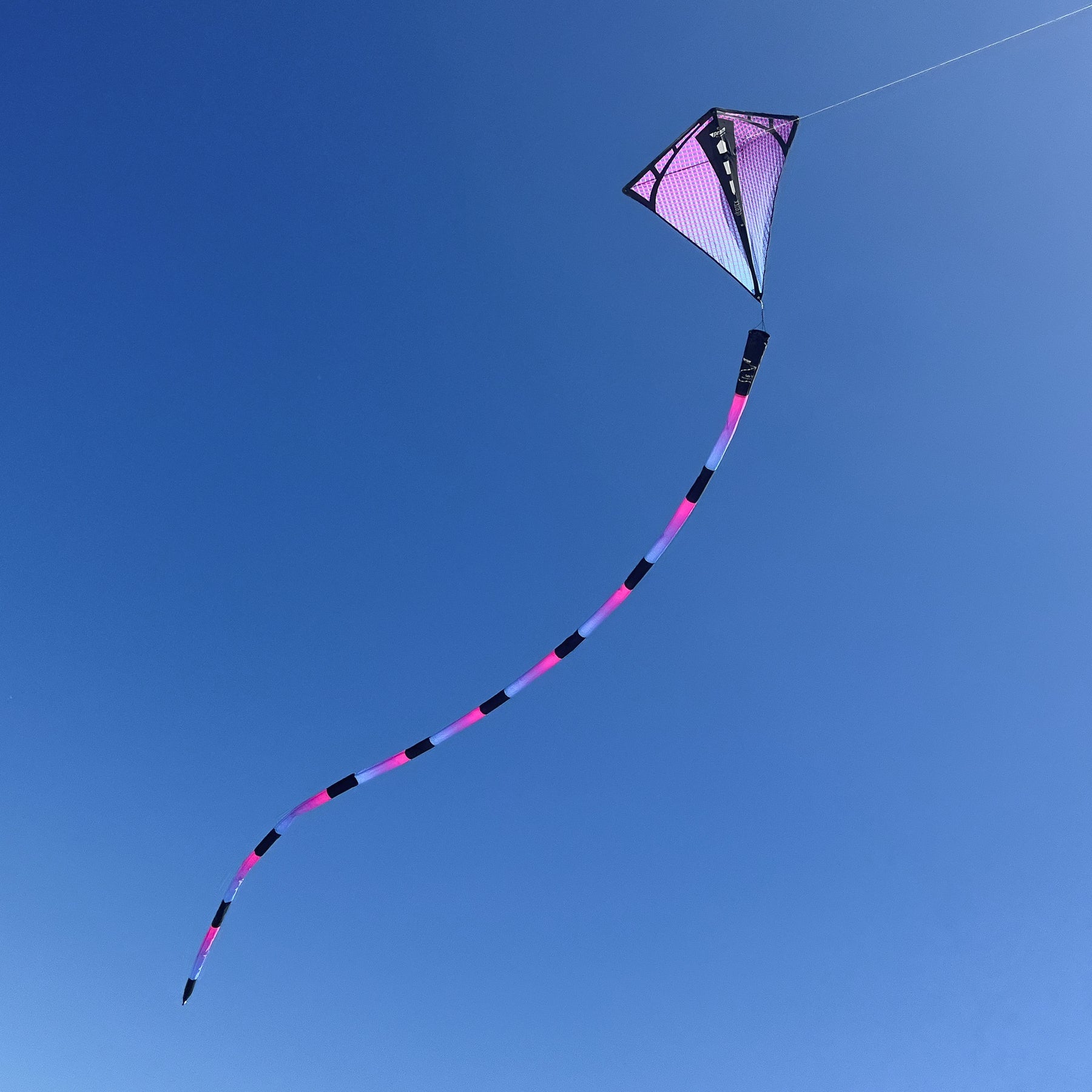 Ultraviolet tube tail with geometric gradient design, inflating airflow construction, and swivel clip for vibrant, motion-filled kite flying.