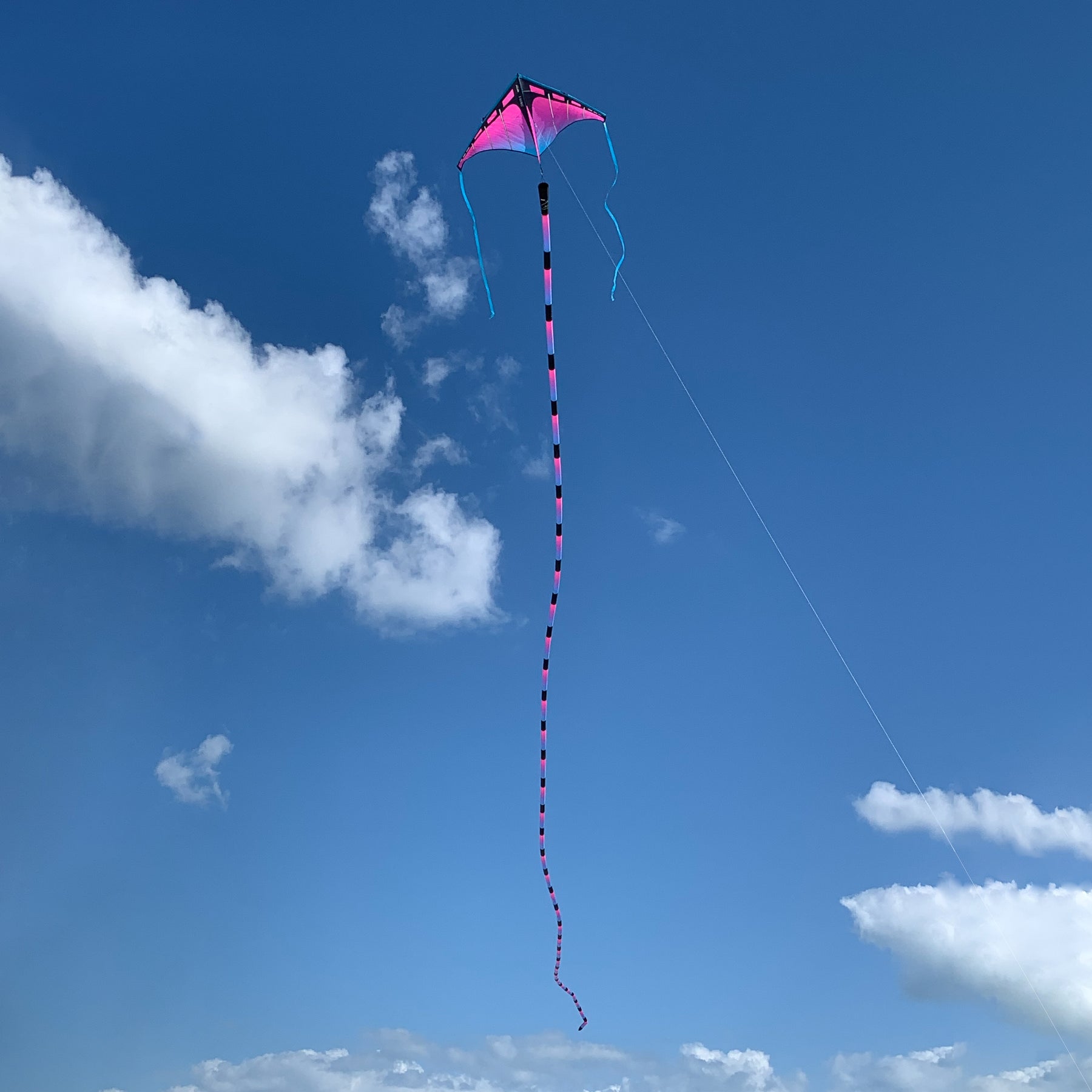 Ultraviolet tube tail with geometric gradient design, inflating airflow construction, and swivel clip for vibrant, motion-filled kite flying.