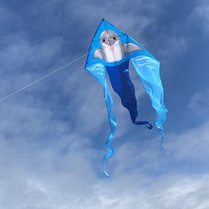Dolphin 52" Wave Delta Kite flying high with colorful dolphin design and long tails against a clear blue sky.