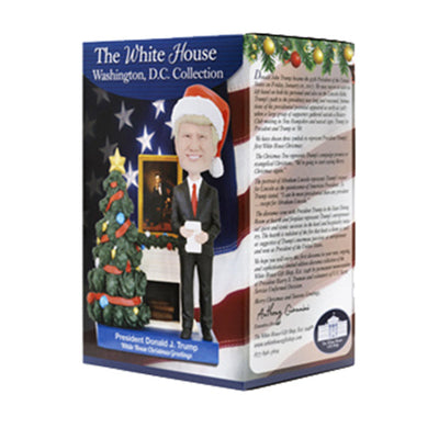 Donald Trump White House Christmas Greetings Bobblehead delicately showcasing President Trump in a festive Santa cap, surrounded by Christmas decorations.