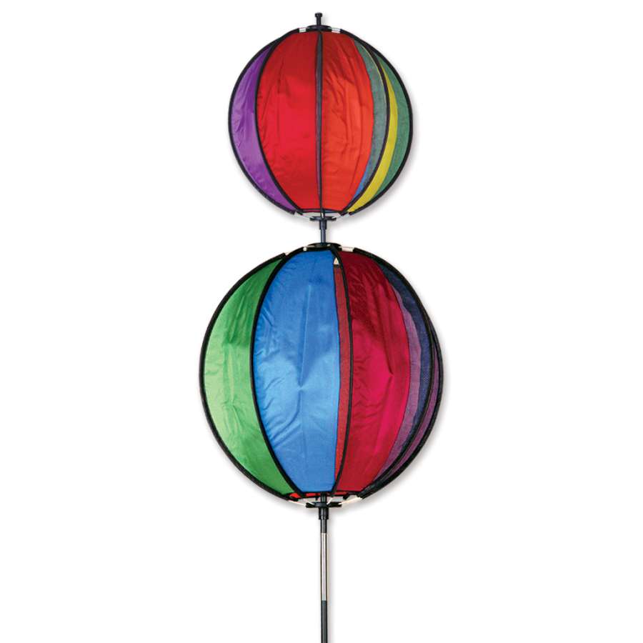 Rainbow Double Ball Spinner standing at 60 inches tall, spinning gracefully in a lush garden, showcasing its vibrant colors against the backdrop of greenery.