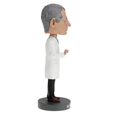 Dr. Anthony Fauci Bobblehead, over 8 inches tall, featuring detailed likeness, displayed on a desk with a vibrant box in the background.