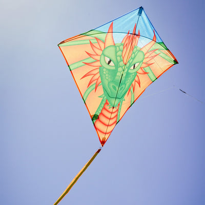 Dragon 30 inch diamond kite with colorful dragon design soaring in clear blue sky, featuring three long tails for stability.