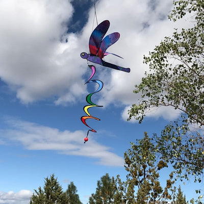 Dragonfly Theme Twister featuring moveable wings and vivid colors, charmingly spinning in a garden setting.