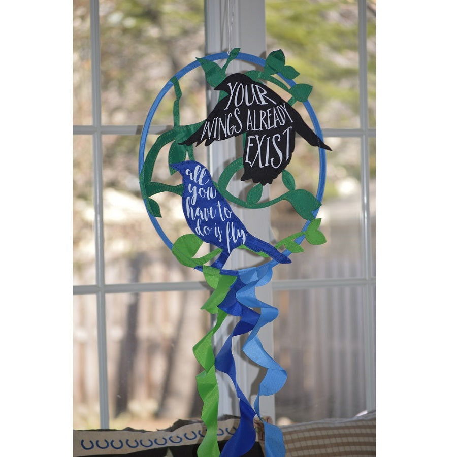 Vibrant Dreamcatcher - Birds design with 15-inch hoop and 18-inch tails displayed outdoors, featuring the uplifting message about flying free.