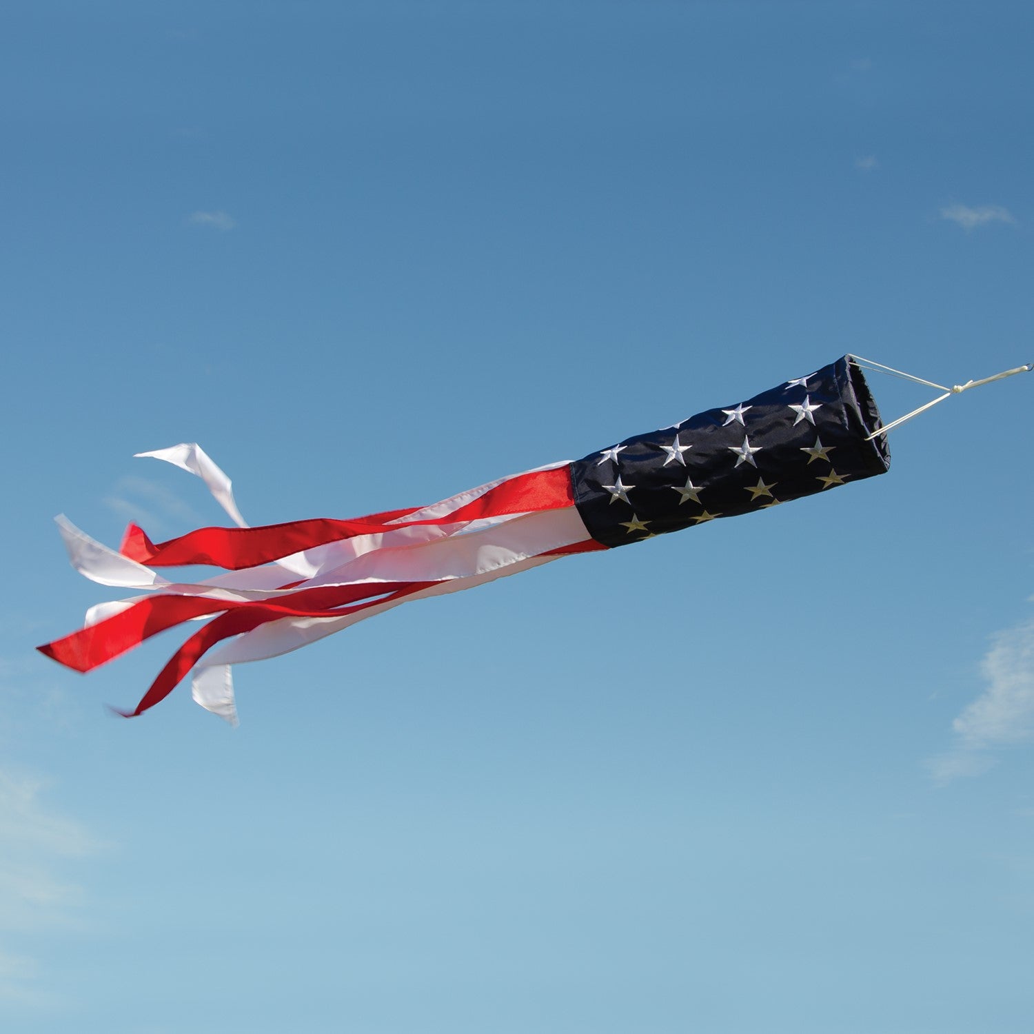 Embroidered Stars & Stripes 50' Value Windsock featuring the American flag design, displayed outdoors with colorful tails fluttering in the wind.