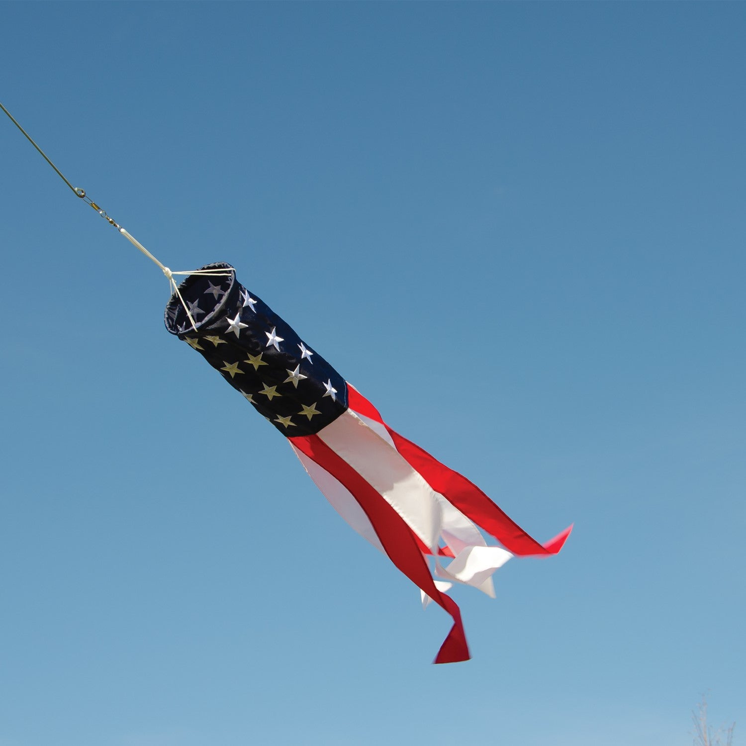Embroidered Stars & Stripes 33\" windsock displaying vibrant red, white, and blue colors with detailed embroidered stars, hanging outdoors.