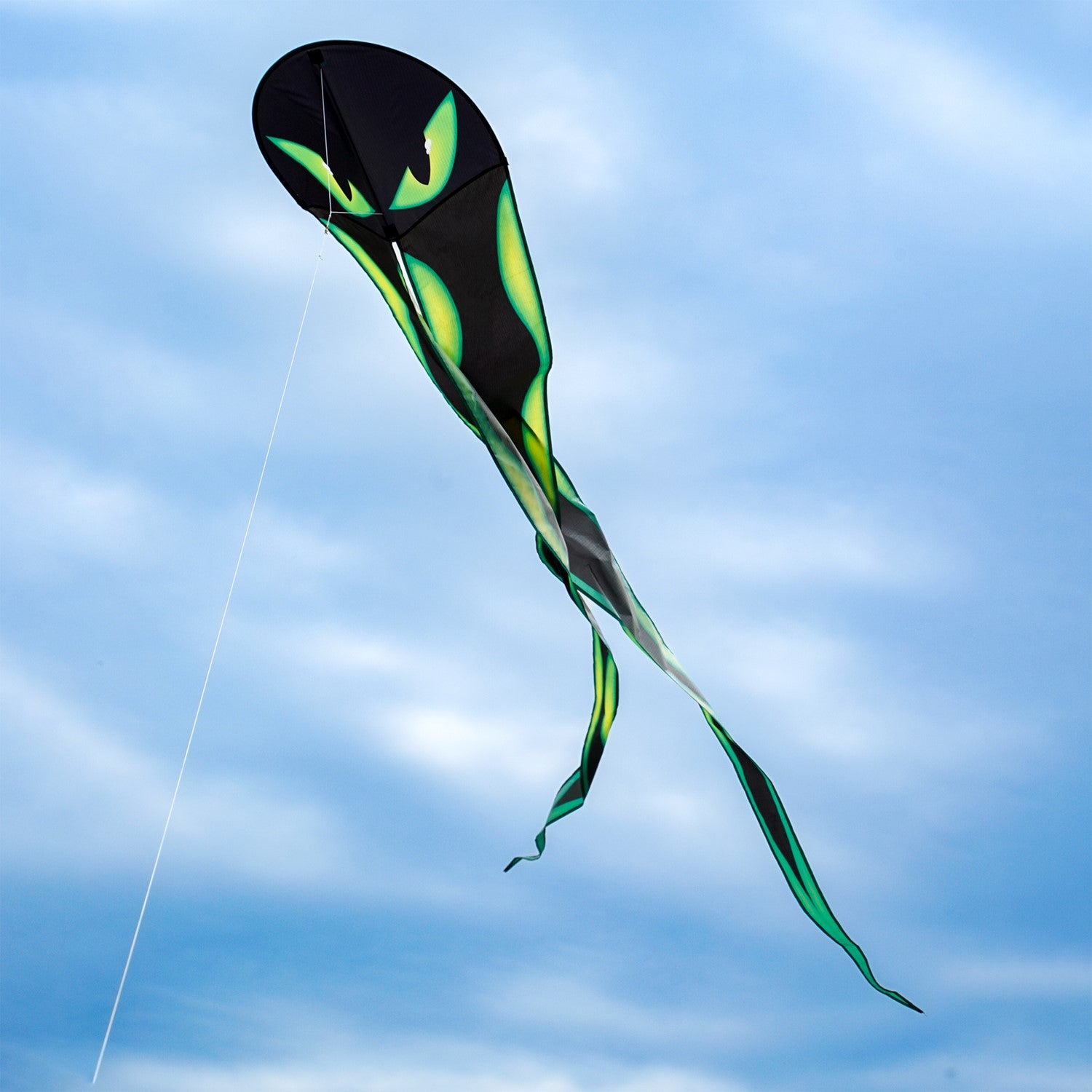 22-Inch Eyes Dancing Dragon Kite soaring in the sky with flowing tails, showcasing vibrant colors and a spooky design during outdoor play.