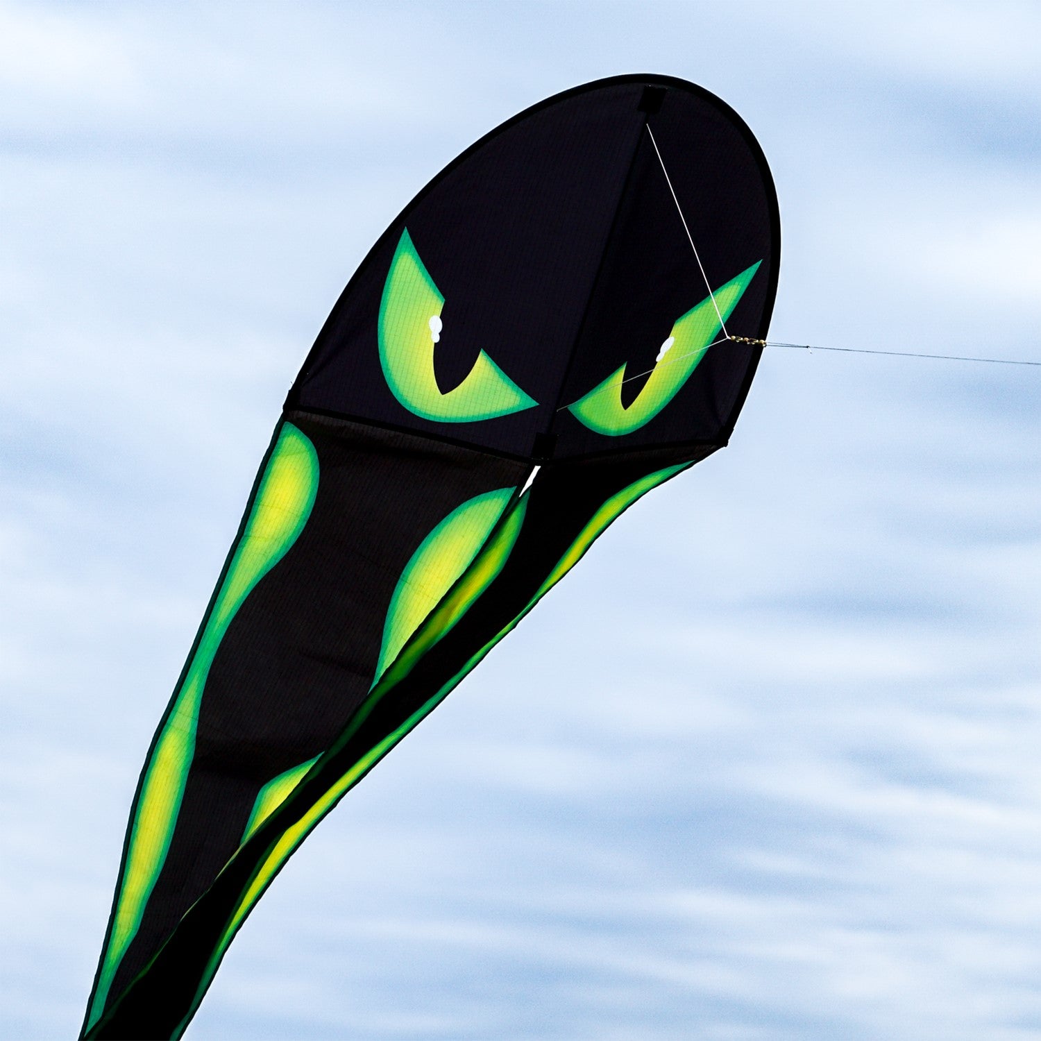 22-Inch Eyes Dancing Dragon Kite soaring in the sky with flowing tails, showcasing vibrant colors and a spooky design during outdoor play.