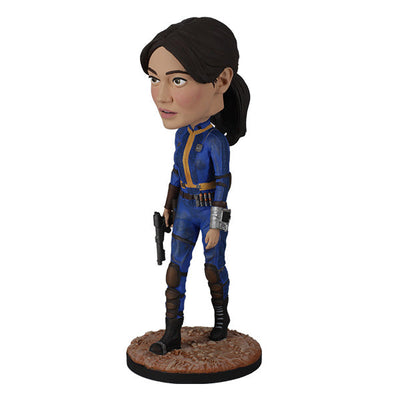 Fallout: Lucy MacLean Bobblehead standing proudly in a Vault 33 jumpsuit, ready for adventure with a rugged base reflecting the Wasteland.