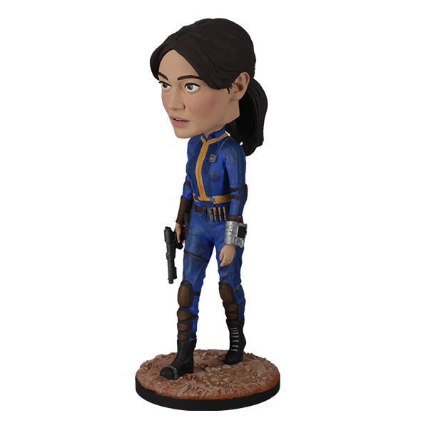 Fallout: Lucy MacLean Bobblehead standing proudly in a Vault 33 jumpsuit, ready for adventure with a rugged base reflecting the Wasteland.