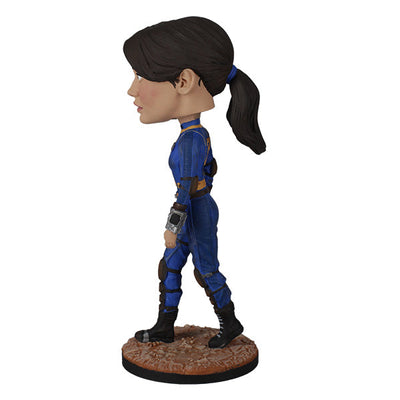 Fallout: Lucy MacLean Bobblehead standing proudly in a Vault 33 jumpsuit, ready for adventure with a rugged base reflecting the Wasteland.