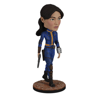 Fallout: Lucy MacLean Bobblehead standing proudly in a Vault 33 jumpsuit, ready for adventure with a rugged base reflecting the Wasteland.