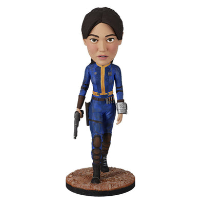 Fallout: Lucy MacLean Bobblehead standing proudly in a Vault 33 jumpsuit, ready for adventure with a rugged base reflecting the Wasteland.