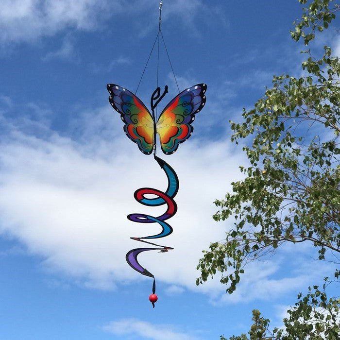 Fancy Butterfly Theme Twister featuring colorful wings that move gently in the breeze, with a vibrant curlie tail, hanging elegantly in a garden setting.