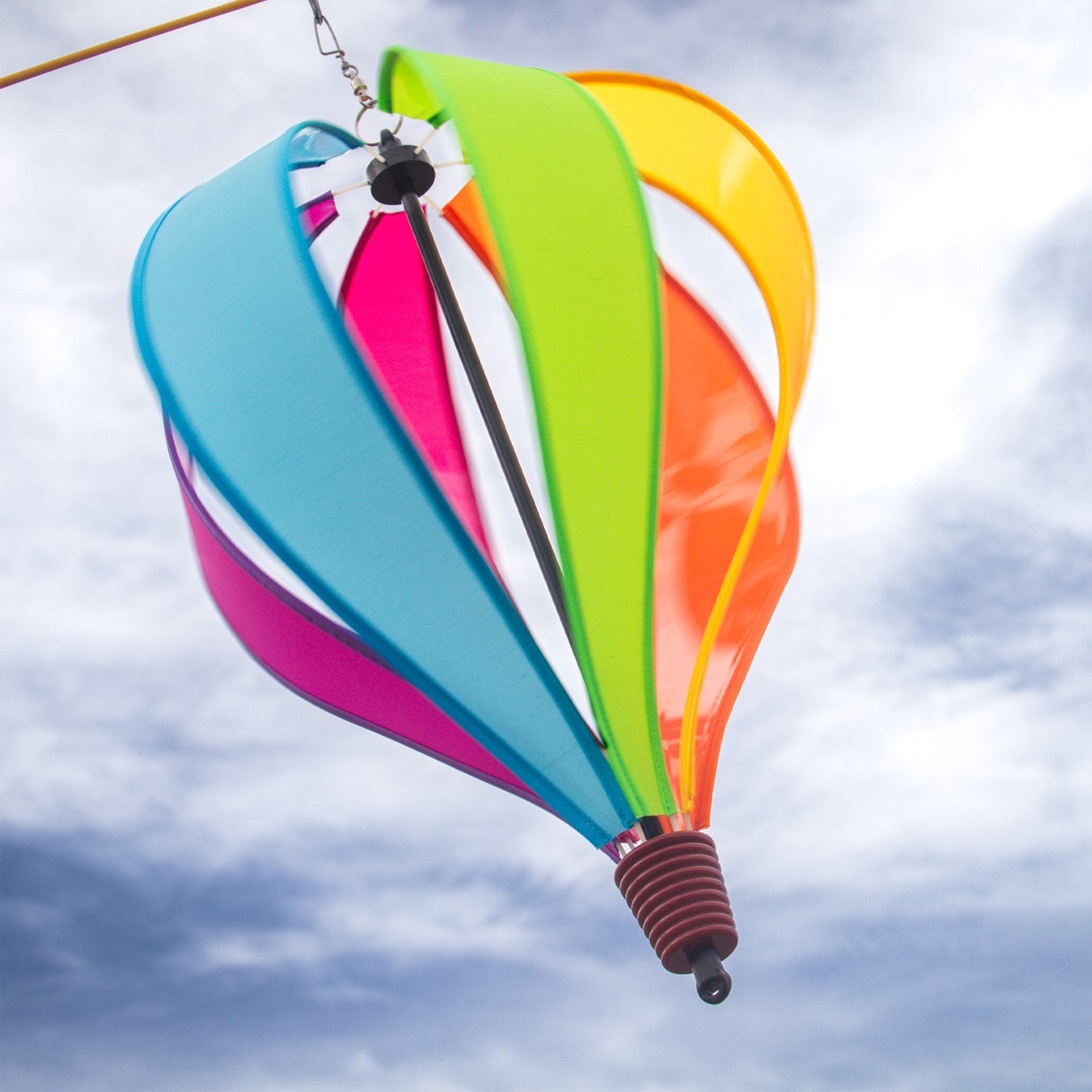 Colorful Fiesta 6-Panel Fabric Hot Air Balloon Spinner in a garden setting, highlighting its vibrant colors and balloon shape for outdoor decor.