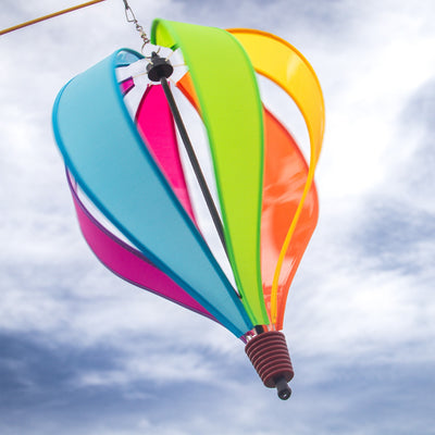 Colorful Fiesta 6-Panel Fabric Hot Air Balloon Spinner in a garden setting, highlighting its vibrant colors and balloon shape for outdoor decor.