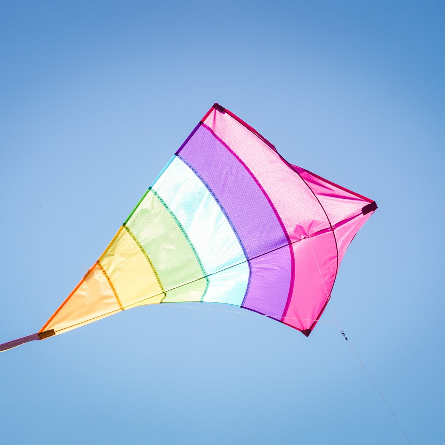 Fiesta Arch 39" Diamond Kite with colorful design flying high against a bright blue sky during outdoor family fun.