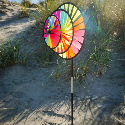 Fiesta Triple Wheel Spinner with three colorful wheels rotating in the breeze on a garden pole, showcasing a bright outdoor scene.