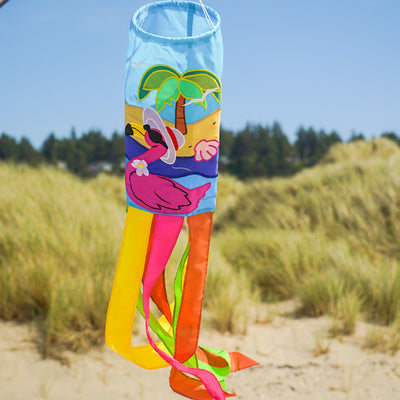 Flamingo 40" windsock with colorful design and embroidered details, fluttering in the breeze in a sunny garden setting.