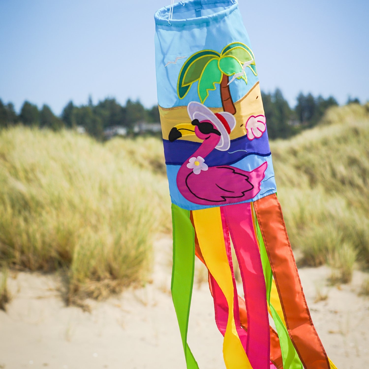 Flamingo 40" windsock with colorful design and embroidered details, fluttering in the breeze in a sunny garden setting.