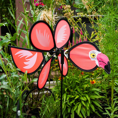 Colorful Flamingo Baby Spinner twirling on a fiberglass pole in a sunny garden, bringing joy and whimsical fun to the outdoor space.