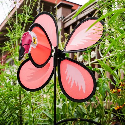 Colorful Flamingo Baby Spinner twirling on a fiberglass pole in a sunny garden, bringing joy and whimsical fun to the outdoor space.