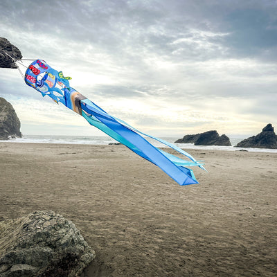 Flip Flops Twistair windsock with eight colorful tails displayed in a sunny garden, featuring whimsical curls that dance in the breeze.