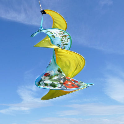 Visual representation of the Flying Critters Spin Duet; a double spinner with beautifully detailed ladybug, dragonfly, and butterfly designs, gracefully spinning outdoors.
