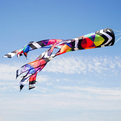 Geometric Black & White 40-inch Illusion Windsock hanging in a garden, featuring embroidered details and stunning printed tails creating a mesmerizing effect.