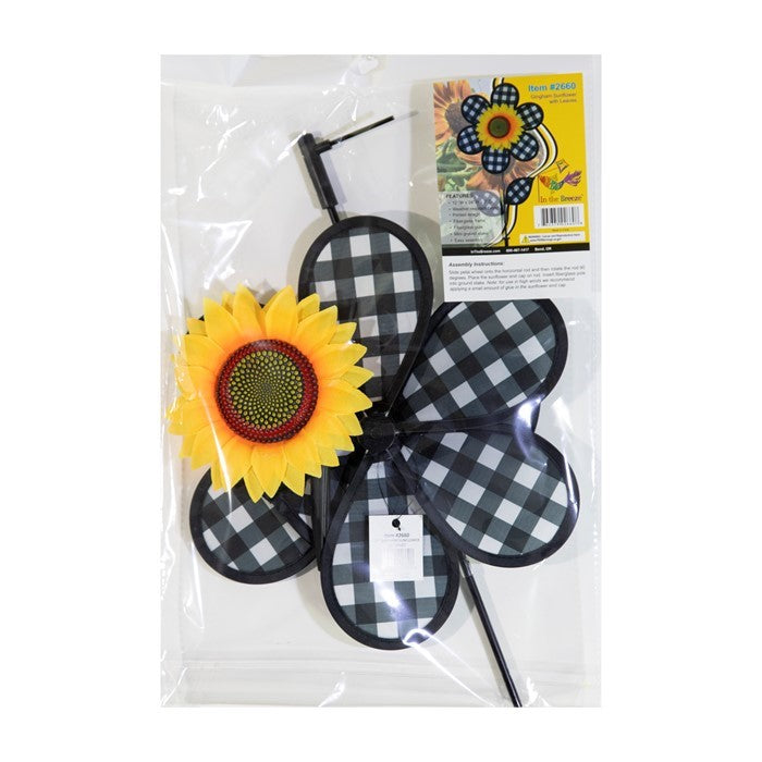 12-inch Gingham Sunflower Ground Spinner with black and white gingham petals and yellow center, spinning in a garden setting on a fiberglass pole.