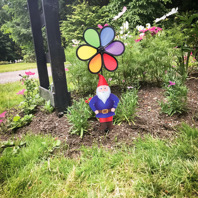 Gnome with 10-inch Rainbow Flower Spinner, featuring a whimsical design to brighten gardens, displayed outdoors with colorful motion in the breeze.