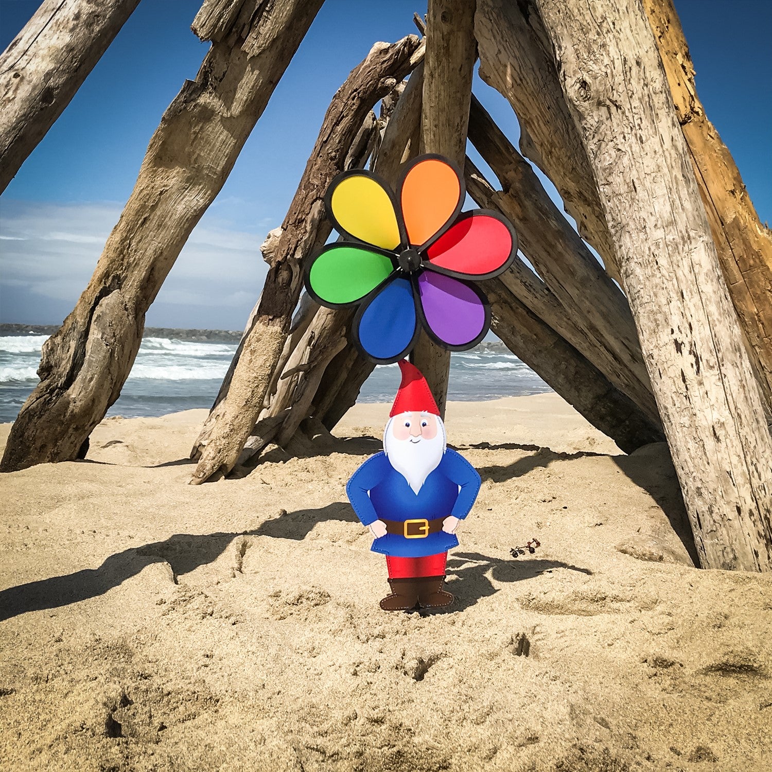 Gnome with 10-inch Rainbow Flower Spinner, featuring a whimsical design to brighten gardens, displayed outdoors with colorful motion in the breeze.