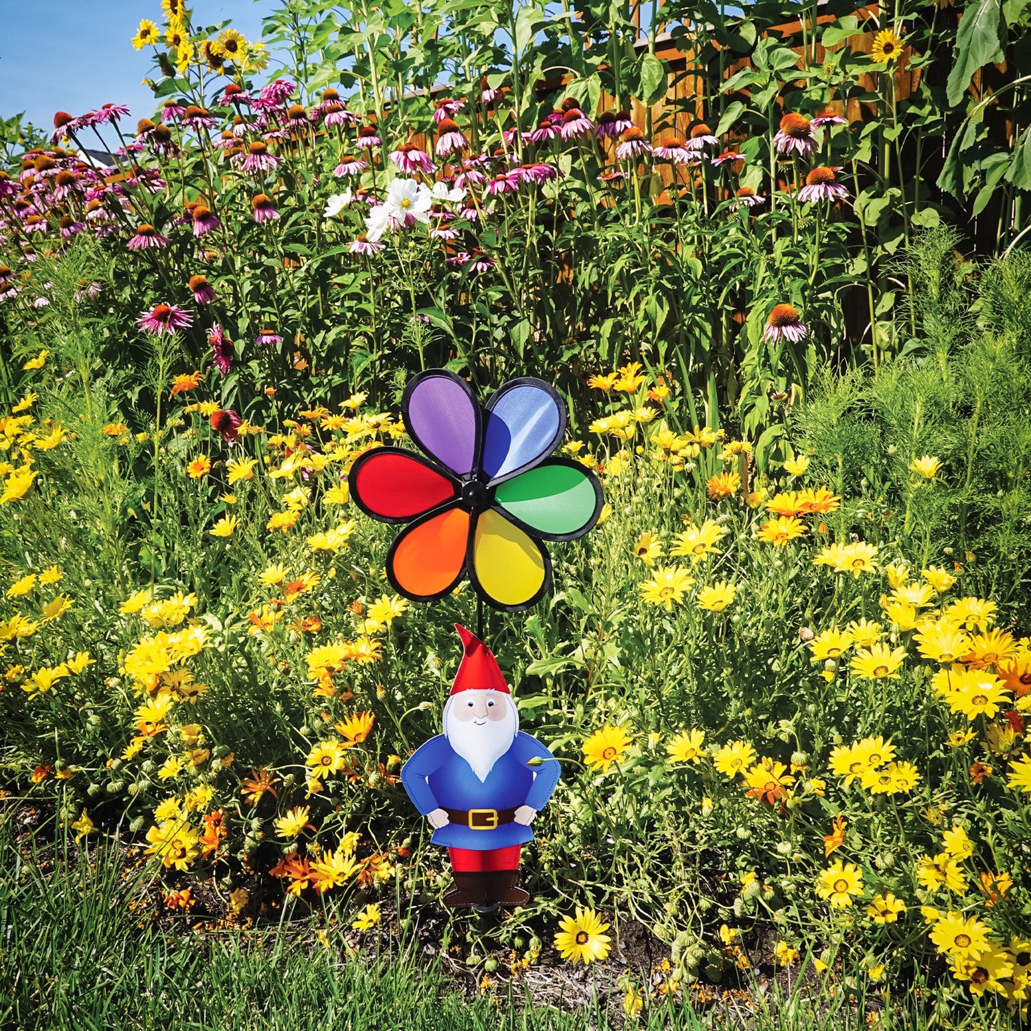 Gnome with 10-inch Rainbow Flower Spinner, featuring a whimsical design to brighten gardens, displayed outdoors with colorful motion in the breeze.