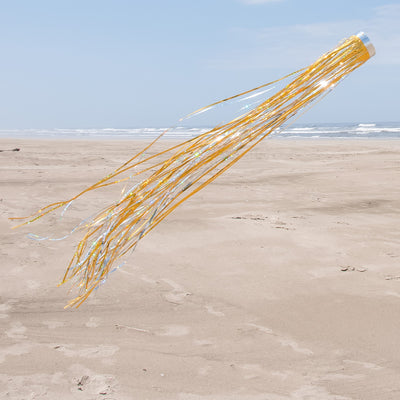 Gold 51-inch Mylar Windsock fluttering in the breeze, showcasing vibrant holographic colors against a clear sky, ideal for garden decorations.
