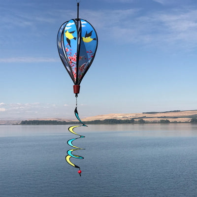 Goldfinch Family Hot Air Balloon garden spinner with colorful designs of goldfinches on cherry tree, displayed outdoors, spinning gently in the breeze.