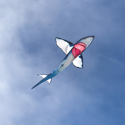 A vibrant 7.5' Great White 3D Shark Kite soaring in a blue sky, showcasing its detailed design and realistic movement, perfect for outdoor fun.