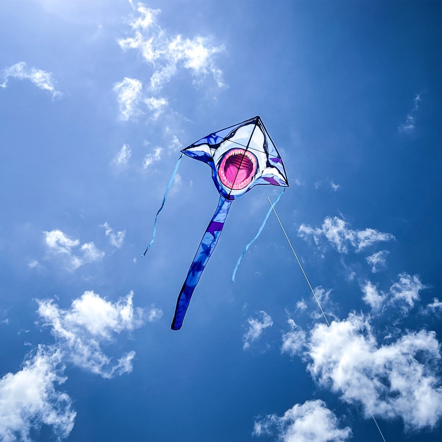 Great White 45' Fly-Hi Kite with a vibrant shark design flying against a blue sky, perfect for outdoor family fun and novice fliers.