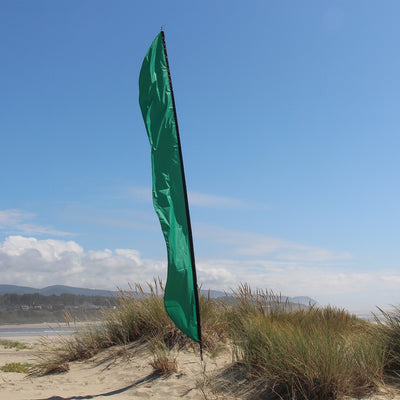 Green 16' Feather Banner displayed outdoors, showcasing vibrant color and elegant movement in the breeze against a clear sky.