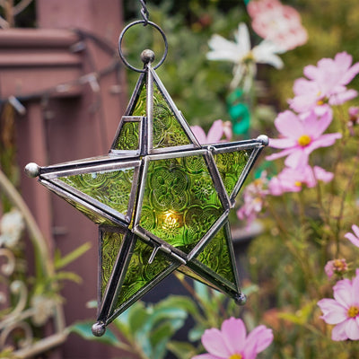 Green 5-Point Star Hanging Tealight Lantern, showcasing textured glass panels and a metal frame, suspended outdoors illuminating the night.