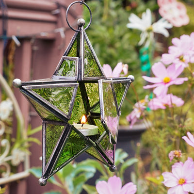 Green 5-Point Star Hanging Tealight Lantern, showcasing textured glass panels and a metal frame, suspended outdoors illuminating the night.