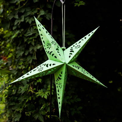 Green Paper Star Lantern with intricate cutouts and gold accents hanging indoors, designed for soft, ambient lighting and decorative appeal.